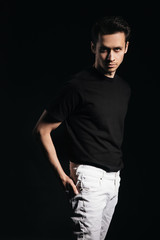 Handsome man, portrait of young man in a black t-shirt, black background