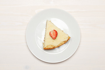 Composition with a piece of cheesecake on a wooden white table. Top view