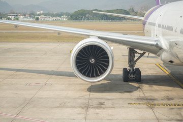 Close up of airplane jet engine on ground at airport.