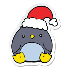 sticker of a cute cartoon penguin wearing christmas hat
