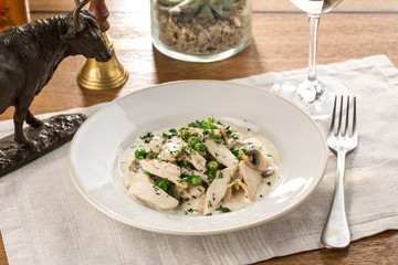 Chicken Fricassee with Green peas and mushrooms on wooden table