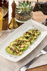 green zucchini grilled with dark stripes on wooden table