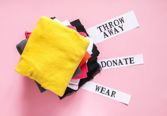 Clothes sorting in wardrobe for donation, wearing and discard with paper notes.