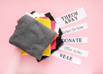 Clothes sorting in wardrobe for donation, wearing and discard with paper notes.