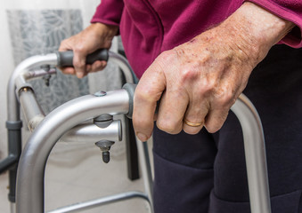Senior man with disability recovery at home walking frames close-up