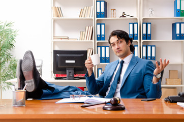 Young handsome judge sitting in courtroom  