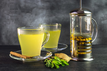 Two mugs and a french press with sea buckthorn tea