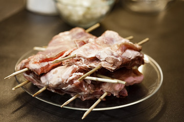 Raw portioned meat on skewers