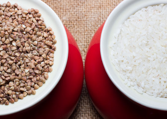 Two red pots of rice and buckwheat on burlap