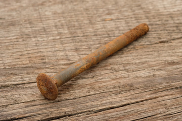 Rostige Schraube aus Metall auf rustikalen Holz