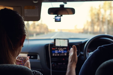 European man with the girlfriend by his side is driving the car on the roadway.