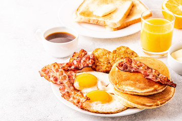 Healthy Full American Breakfast with Eggs Bacon Pancakes and Latkes.