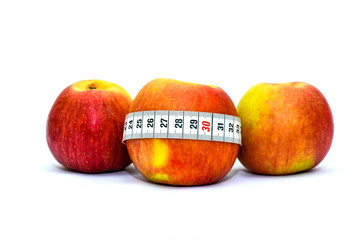 Photo isolated on white background apples and measuring tape. Healthy food for weight loss and keeping fit. Tape for measuring the waist and apples.