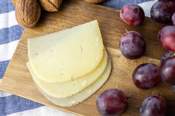 Wooden tray with cheese and grapes