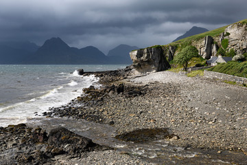 Allt Port na Cullaidh river at Elgol beach with Red Cuillin Mountains under clouds at Loch Scavaig Scottish Highlands Isle of Skye Scotland