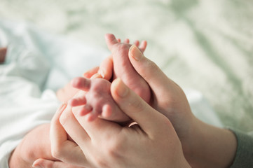 baby feet in mother's hands