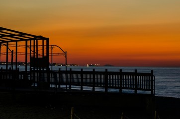 Fototapeta premium Edificio sul mare durante il tramonto con bellissimo cielo arancione