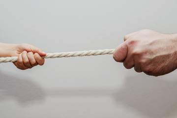 Dragging a child's rope with an adult. Conflict of children with adults. Concept of problems of children and adults. Misunderstanding of children and their needs, imposing the will of adult children.