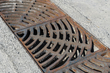 Drain of metal grate around with rough beton road