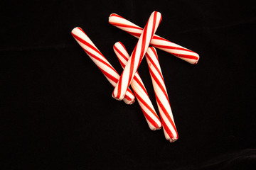 Five Peppermint Sticks on a black background