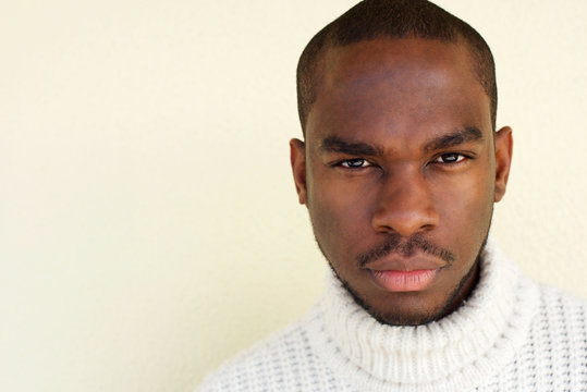 Close up handsome african man with sweater by wall