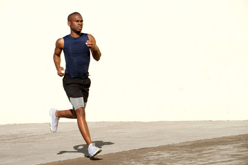 healthy young black man running outside on street