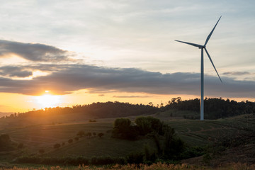Silhouette of wind turbines on the mountain at sunset.