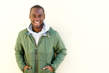 happy african american man posing in windbreaker by wall