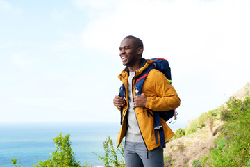 happy african american man with backpack outdoors - Powered by Adobe