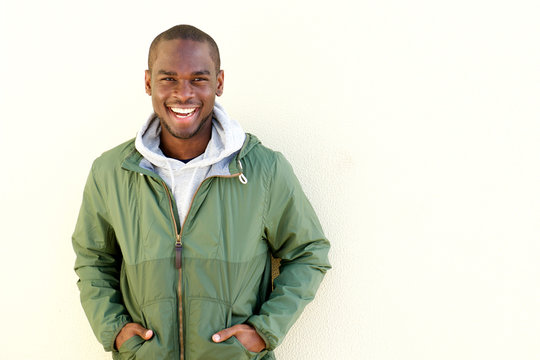 Happy African American Man Posing In Windbreaker By Wall