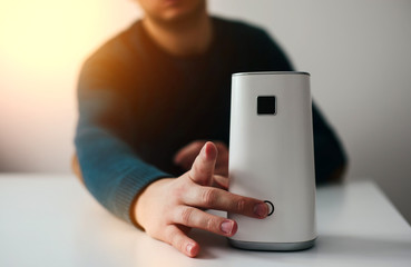 White air ionizer on light background. The concept of taking care of the air in the apartment, taking care of the well-being. Air filter.