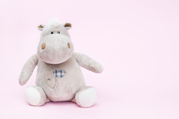 Hippo toy on a pink background, copy space