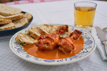 Close up picture of traditional czech dish, chicken with sweet pepper or paprika creamy sauce with bread dumplings served on rustic plate with class of apple cider. Typical for czech or middle europe.