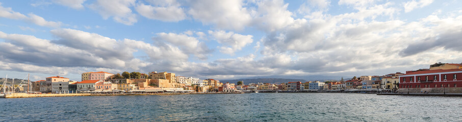 Fototapeta na wymiar The city of Chania is a port on the west coast of the Cretan Sea in Greece. A tourist attraction, a long quay, interesting architecture, a Turkish bath building, houses. Mountains on the horizon.