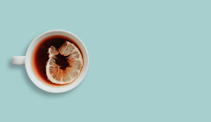 Top view of a cup of tea with lemon isolated on a pastel background. Tea drinking concept, adding...