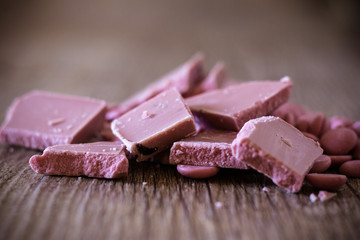 Broken and shattered pieces of ruby red chocolate in a round charcoal stone ceramic bowl.