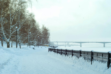 frozen river, quay fence and road bridge away