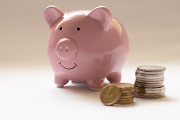 Pink piggy bank with coins on the table. Australian currency.