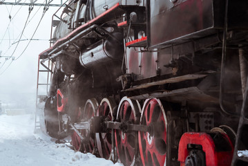 closeup of a steam locomotive wheels with valve gear