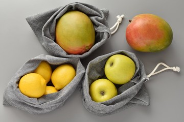 Reusable linen grocery bags with fruits, less plastic concept, zero waste lifestyle.
