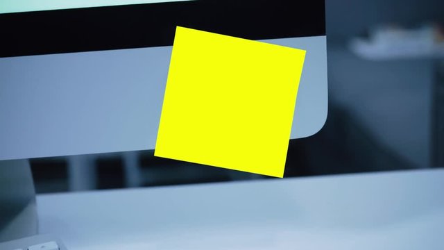 Paper yellow sticker on the monitor. Reminder. List of important cases. A message for an employee, a colleague. Place for the inscription. For tracking. Isolated. Office.