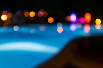 Illuminated swimming pool at night time. Unfocused background.