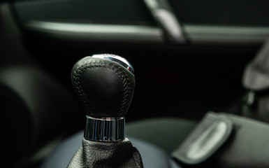 Gear knob in the car. Black leather manual gear knob inside the car. Car interior concept, manual...