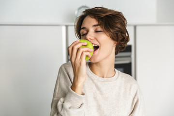Smiling young woman holding green apple