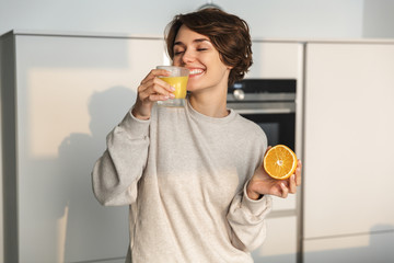 Smiling young woman holding orange