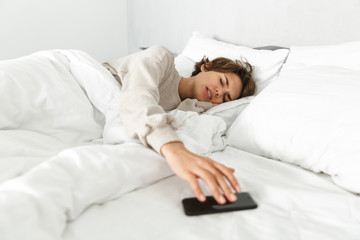 Attractive young girl relaxing in bed in the morning