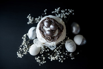 Traditional Easter cake with silver painted eggs on a black background. Selective focus