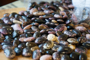 Close-up of colorful haricot beans, beans on wooden table