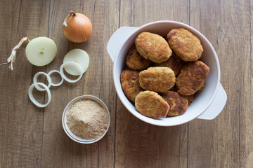 Fried beef cutlet on plate with onion and salat