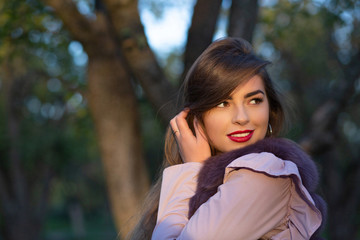 Spring portrait of glorious young model with red lips walking in the park. Empty space